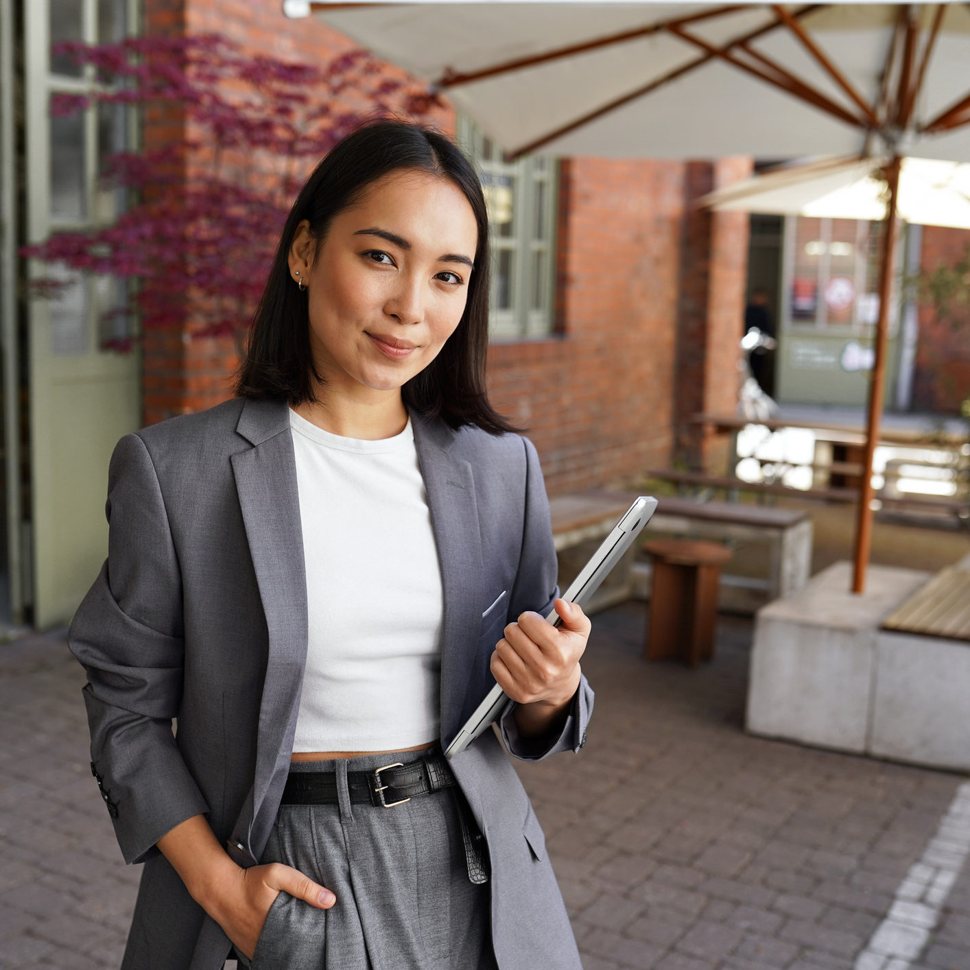 Young elegant professional leader Asian woman, female executive retail manager supervisor, small business owner wearing suit holding digital tablet standing outdoor looking at camera, portrait.